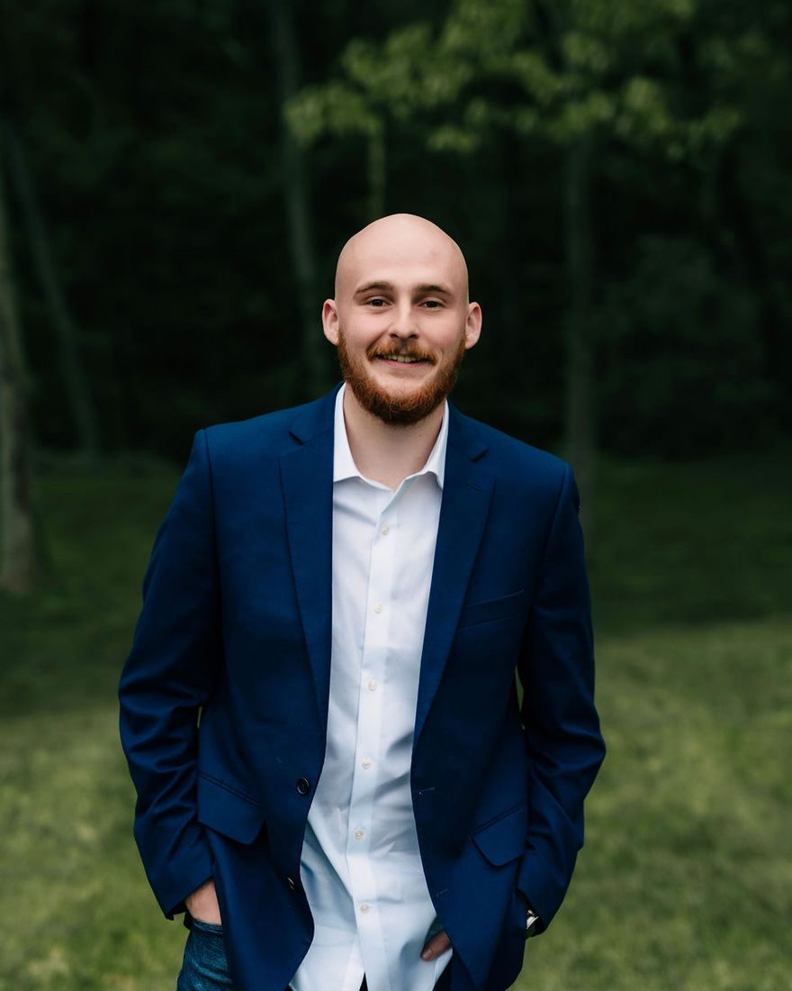 Cooper Morter in a navy blazer, smiling, outdoors